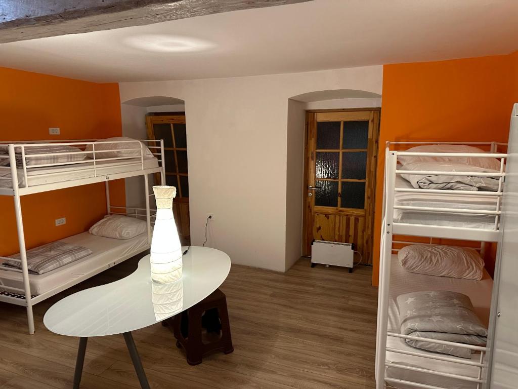 a room with two bunk beds and a table at Hostel Sleeping Beauty in Ljubljana