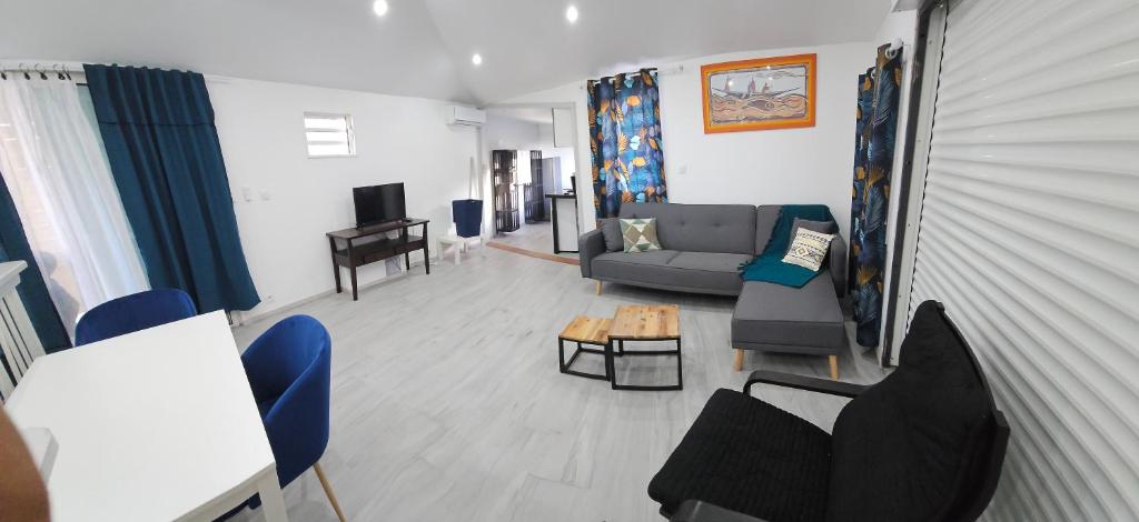 ein Wohnzimmer mit einem Sofa, Stühlen und einem Tisch in der Unterkunft Chez les Rakoto in Koungou
