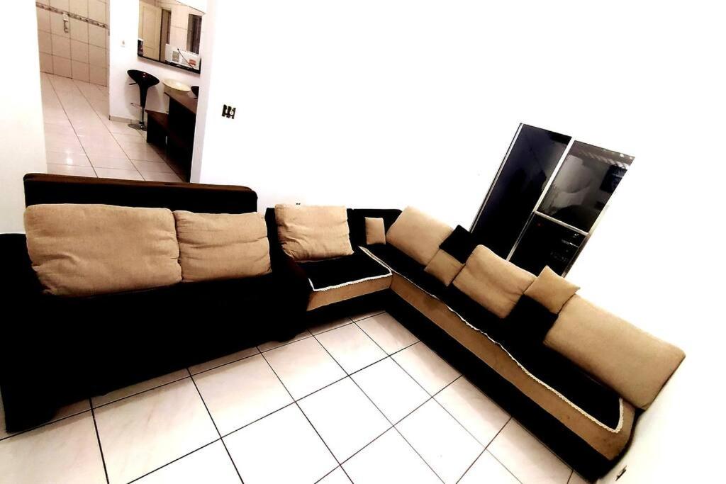 um sofá preto sentado numa sala de estar em Grandes Grupos Casa 2 em São Paulo