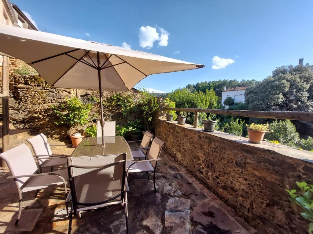 a patio with a table and chairs and an umbrella at El Descanso de Las Hurdes 