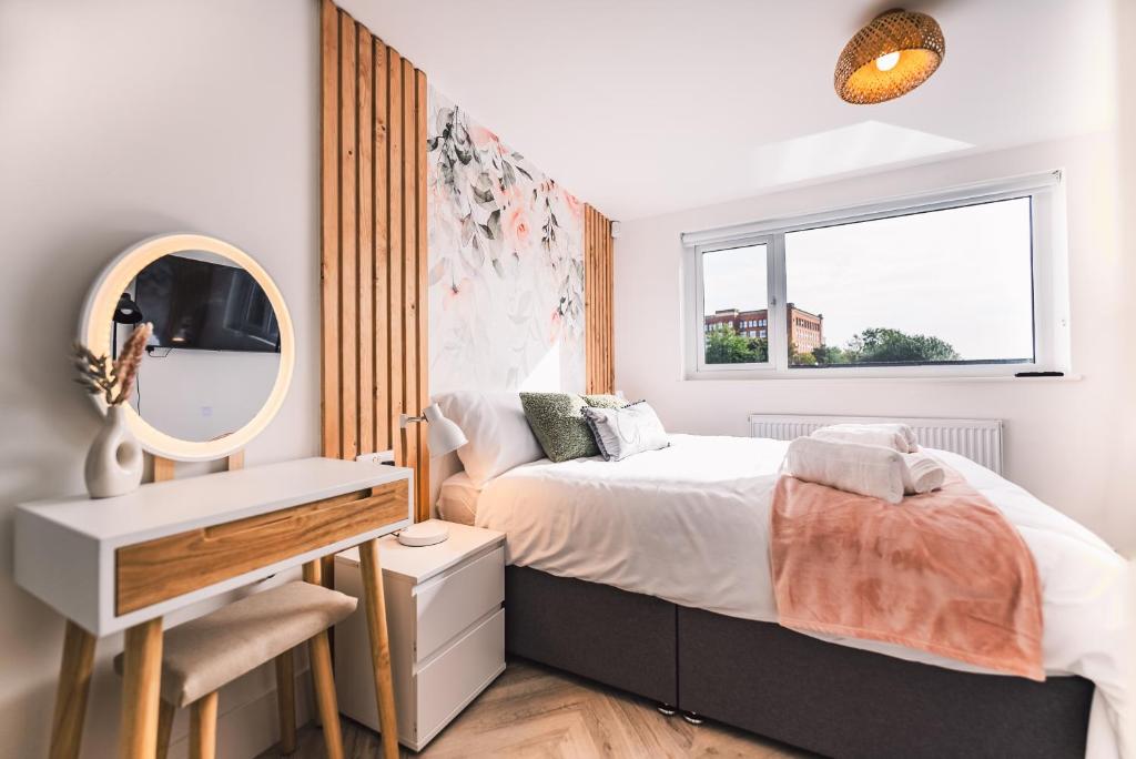 Schlafzimmer mit einem Bett und einem Spiegel in der Unterkunft Luxurious 3 Bed Home, Free Parking in Manchester