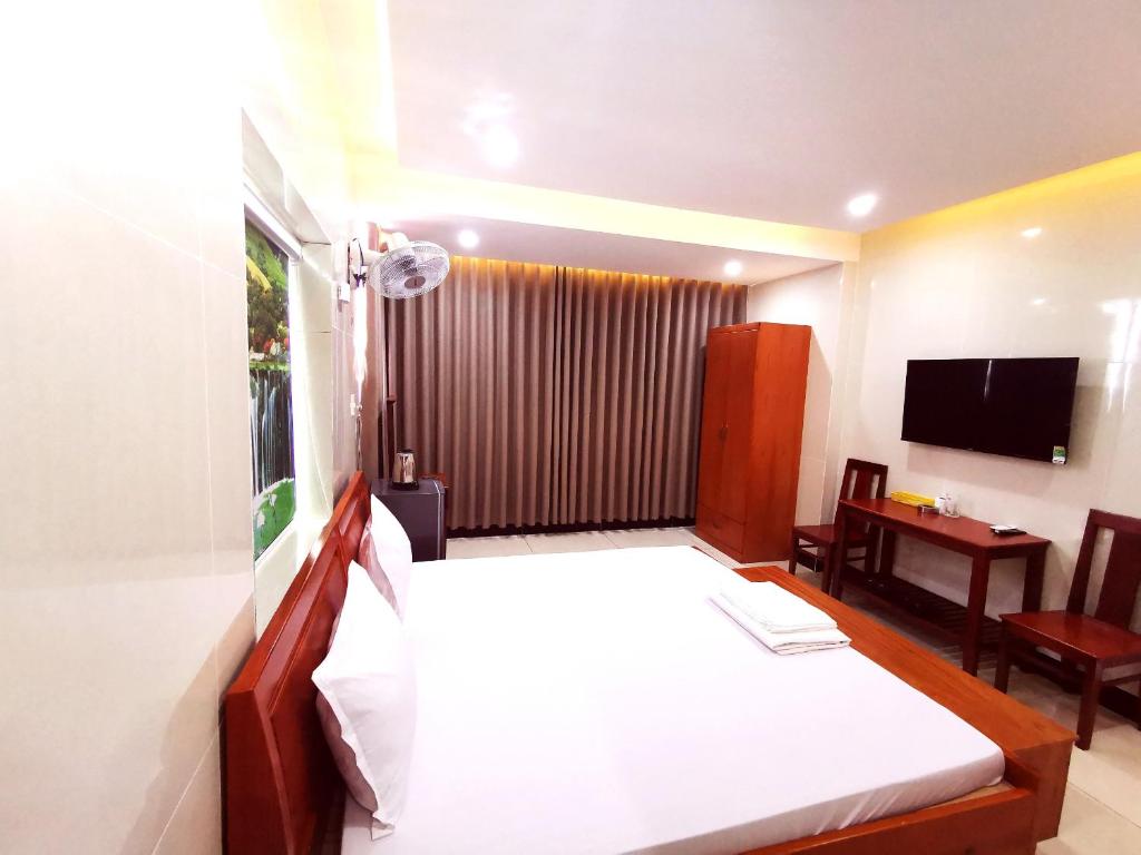 een hotelkamer met een bed en een televisie bij KHÁCH SẠN CÚC PHƯƠNG (CÚC PHƯƠNG HOTEL) in Dĩ An