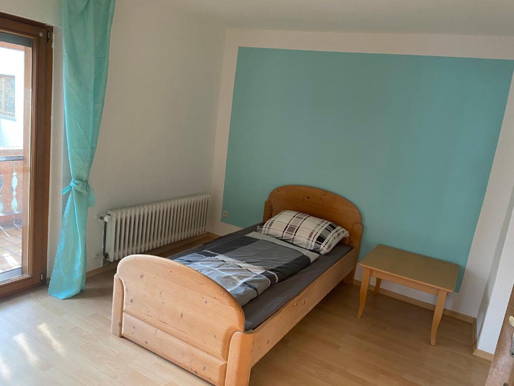 ein kleines Schlafzimmer mit einem Holzbett und einem Tisch in der Unterkunft Monteur Wohnung Unterkunft in Hohberg