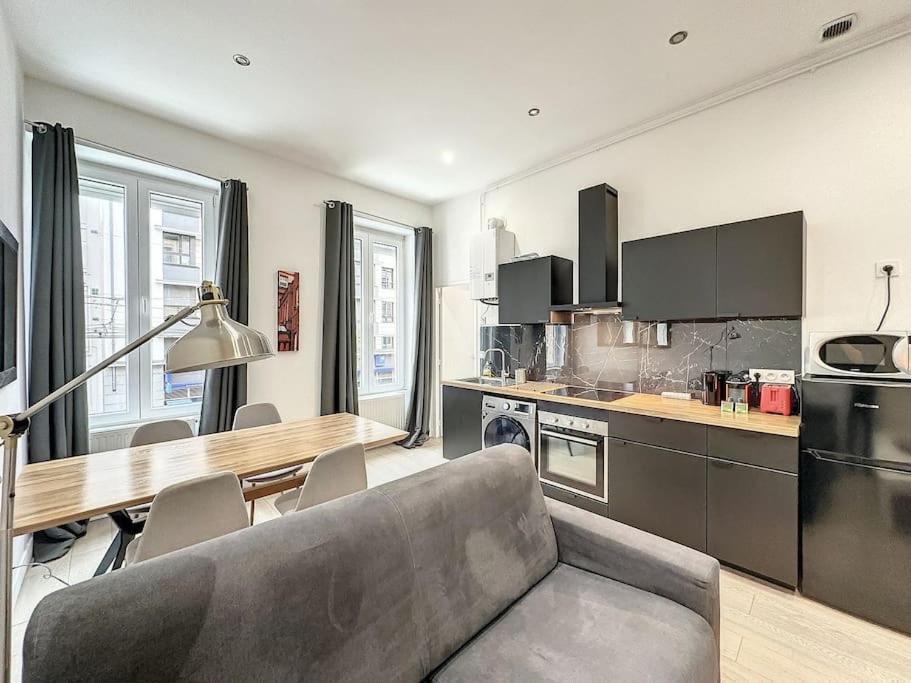 un salon avec un canapé et une table dans une cuisine dans l'établissement Cosy appart - lyon 6 - Gare Partdieu - Lafayette 1, à Lyon