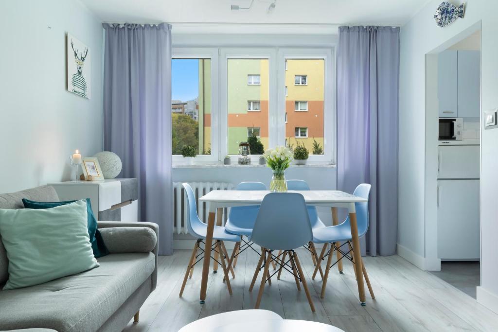 a living room with a couch and a table and chairs at Elite Apartments Brzeźno Family in Gdańsk