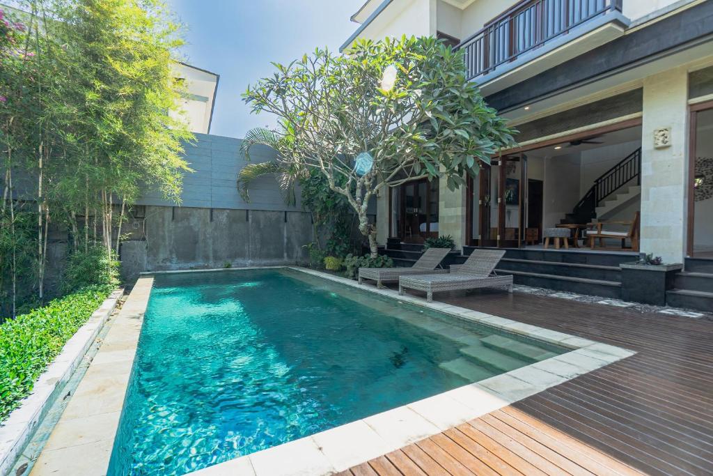 a swimming pool in the backyard of a house at Belle Asana in Canggu