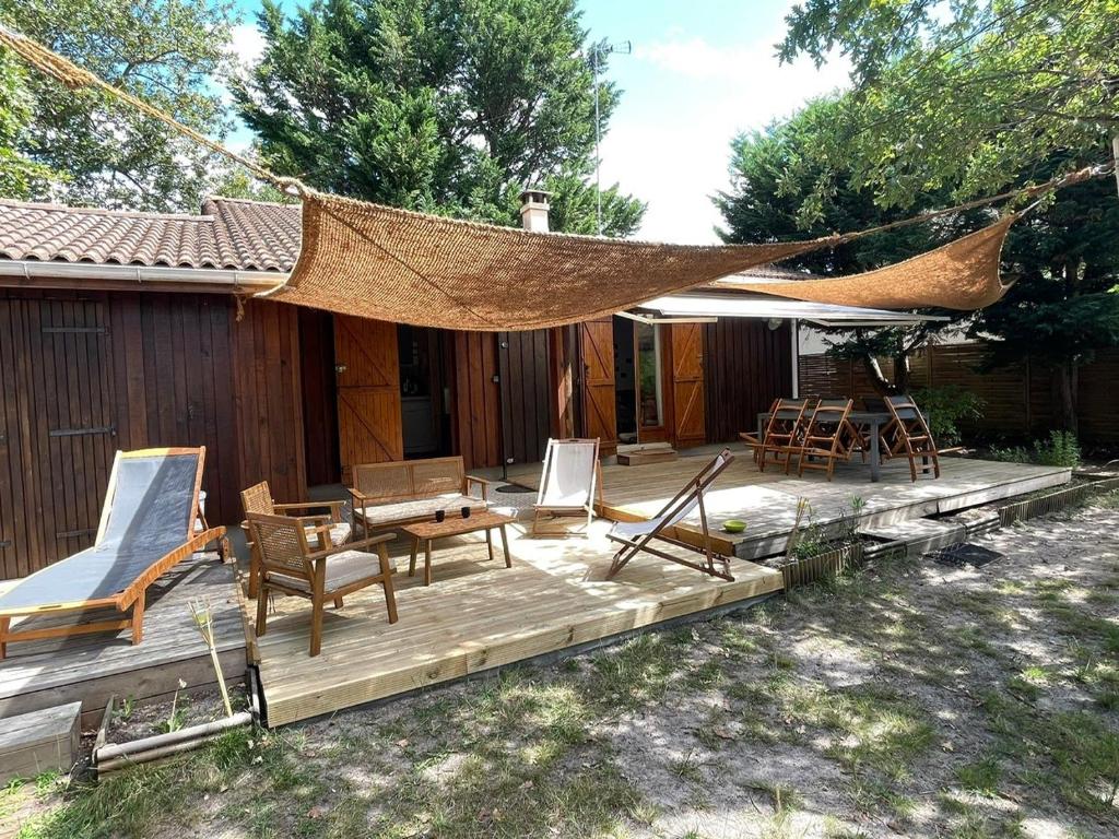 une terrasse avec des chaises et un hamac, ainsi qu'une maison dans l'établissement Cabane C60, à Lège-Cap-Ferret