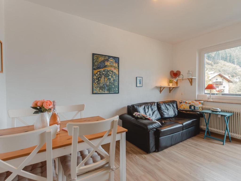 een woonkamer met een zwarte leren bank en een tafel bij Apartment Smilla by Interhome in Bad Gastein