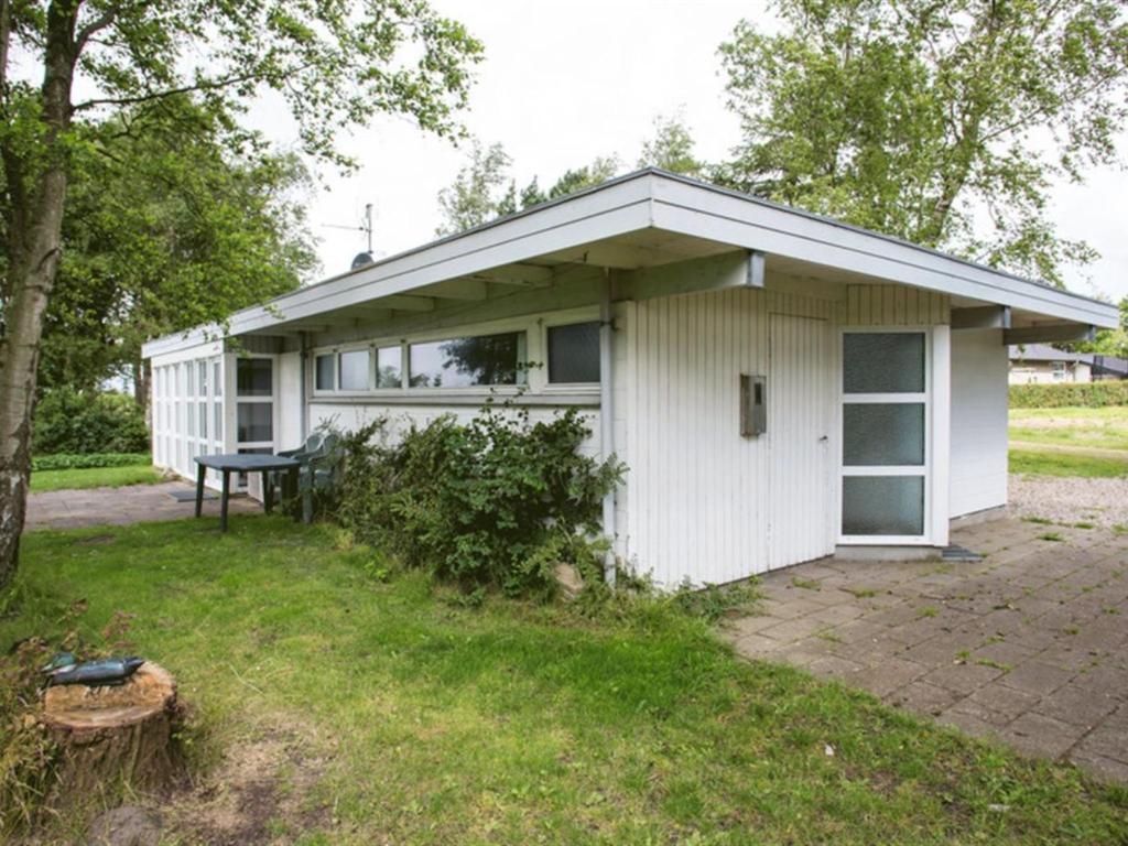 una casa blanca con una mesa de picnic delante de ella en Holiday Home Thara - 100m from the sea in SE Jutland by Interhome, en Sønderby