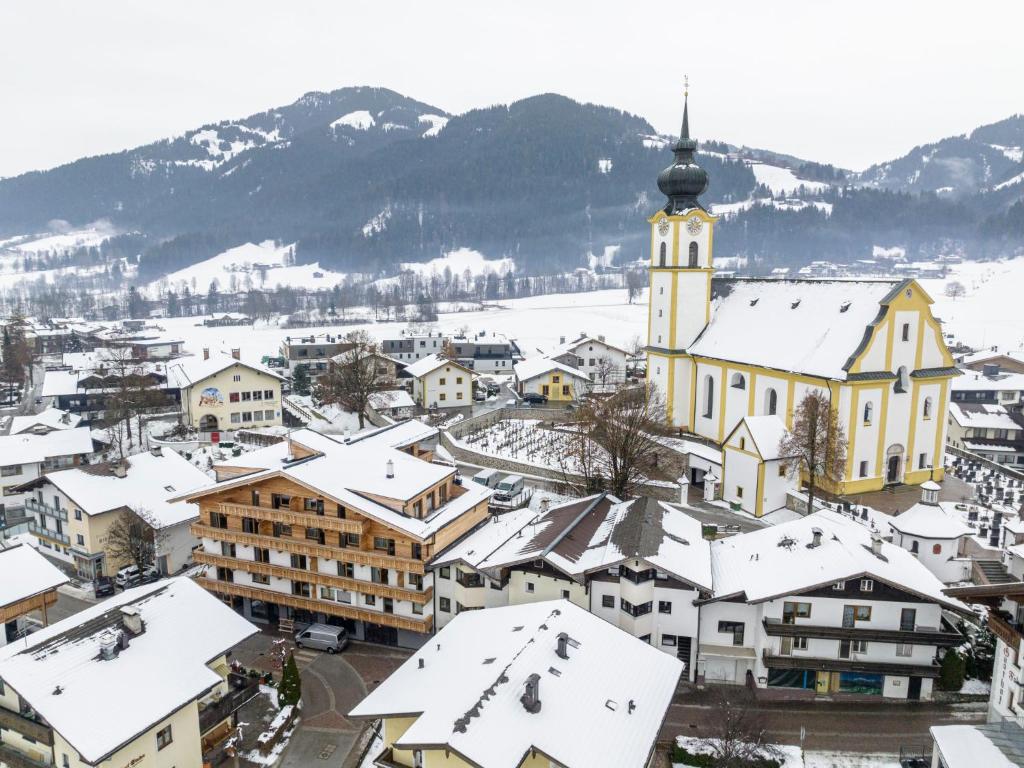 a town with snow covered roofs and a church at Apartment Family 03 by Interhome in Söll