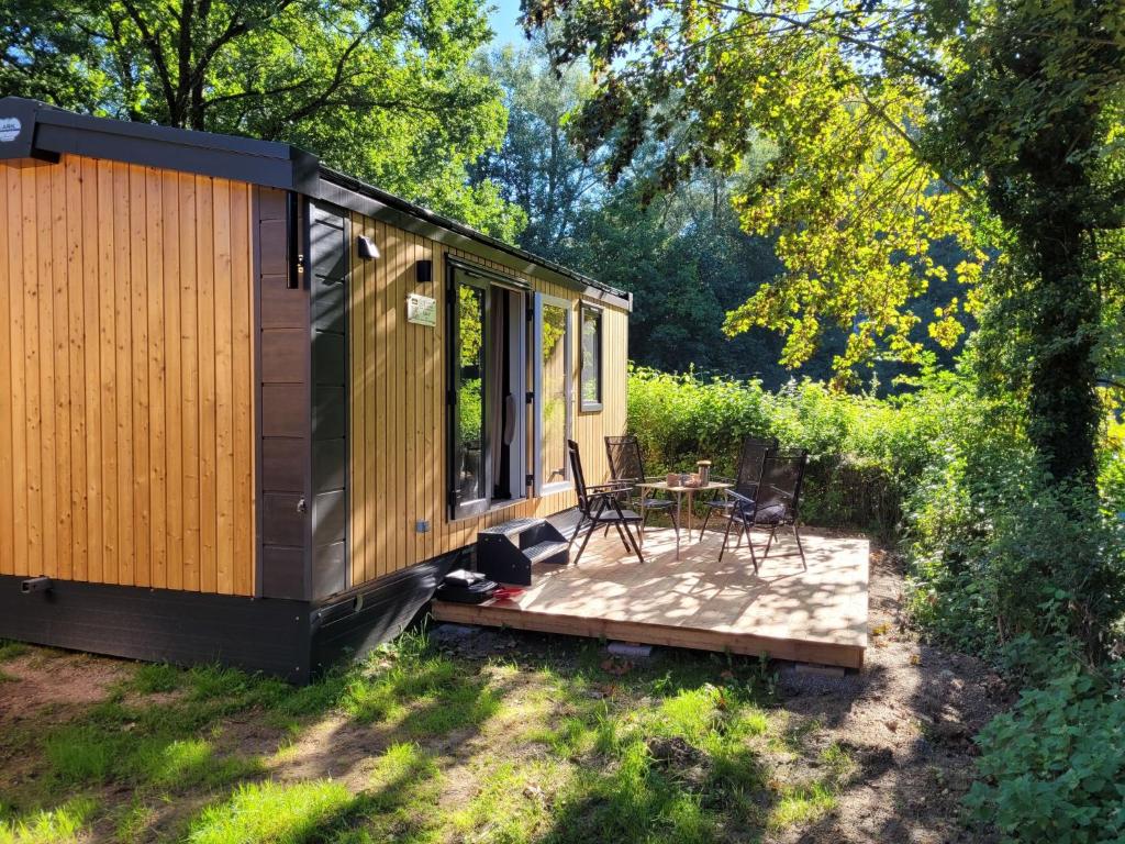 una cabina con terrazza, tavolo e sedie di Holiday Home Tiny Haus Soul & Forest by Interhome a Wemding