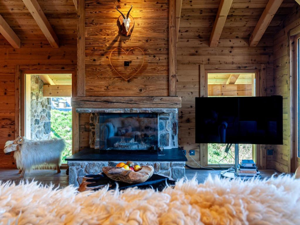 sala de estar con chimenea y TV de pantalla plana en Chalet Skyfall by Interhome, en Les Collons
