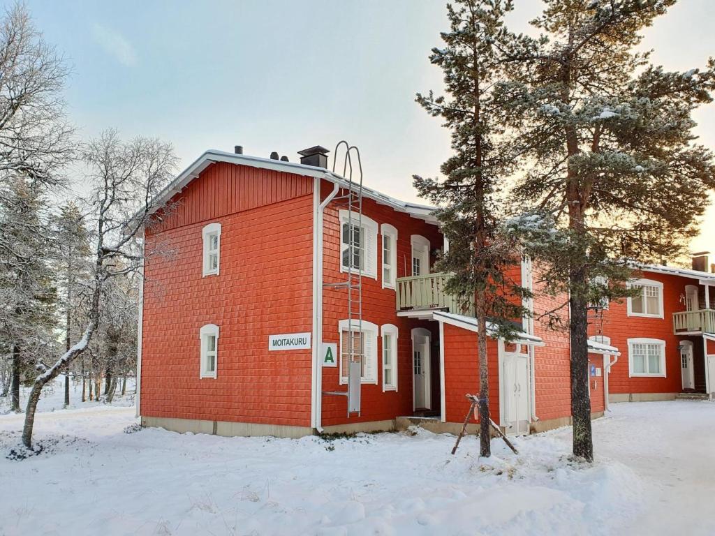 a red brick building in the snow with a tree at Holiday Home Moitakuru a6 by Interhome in Saariselka