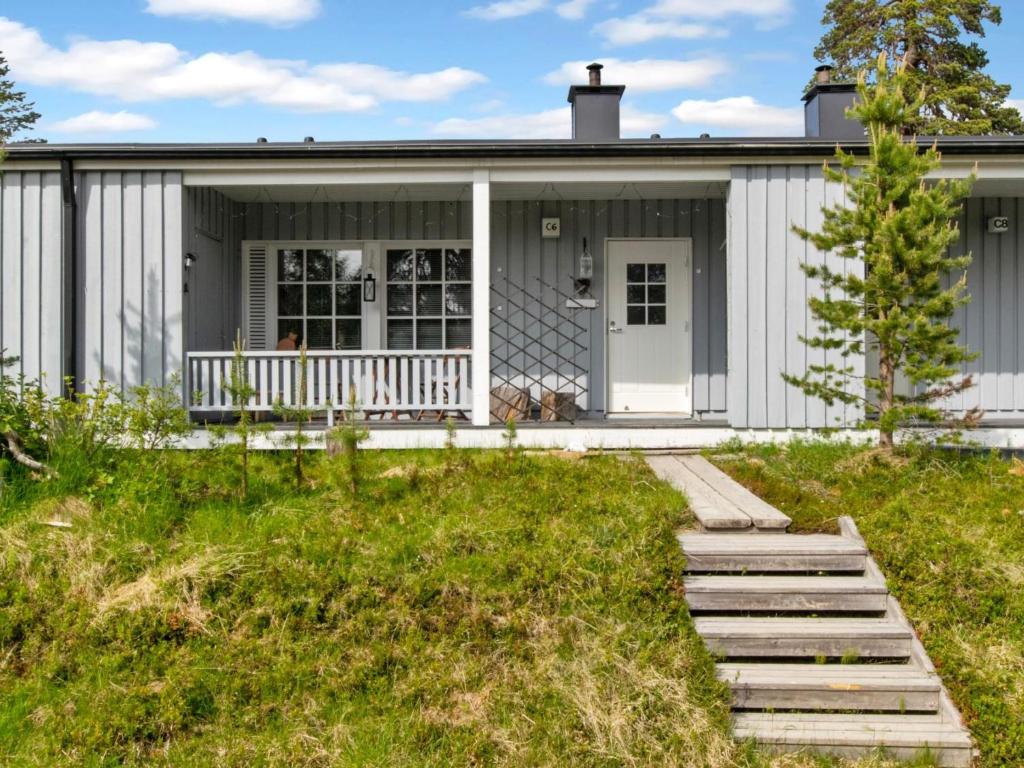een wit huisje met een veranda en een trap die naar het huis leidt bij Holiday Home Saariseläntie 8 c 6 alatupa by Interhome in Saariselkä