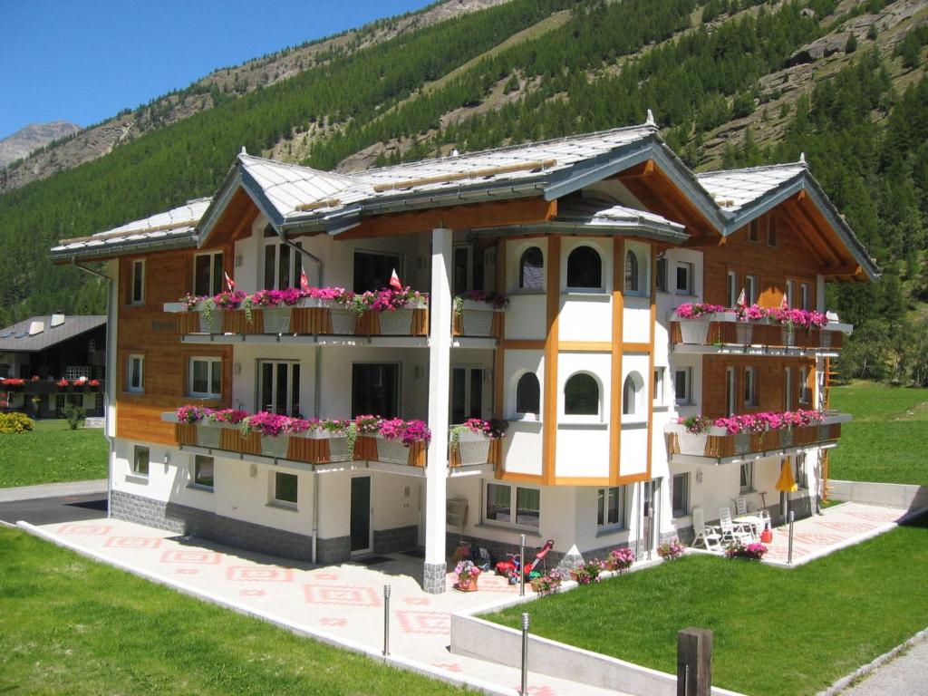 ein Haus mit Blumen auf den Balkonen in der Unterkunft Apartment Haus Alpenstern- Wohnung Distel by Interhome in Saas-Grund