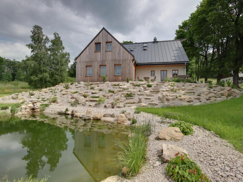 a house on an island in the water with a rock garden at Apartment U Krále-2 by Interhome in Kořenov