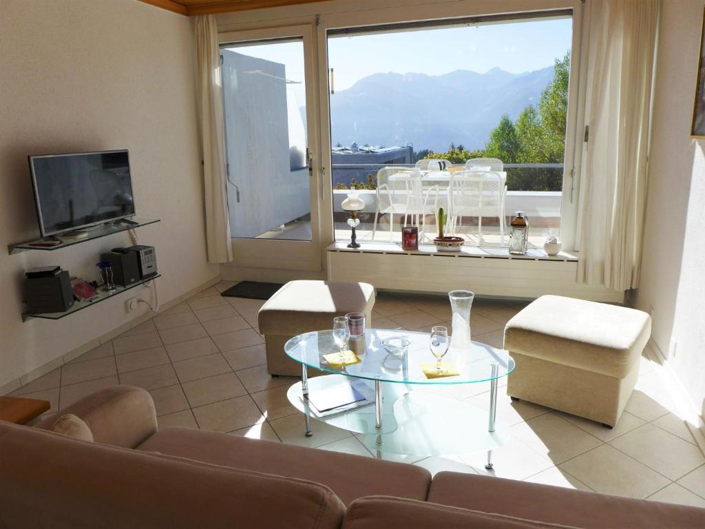 Una sala de estar con un sofá y una mesa de cristal. en Studio Jeanne D'Arc Apt- B-11 by Interhome, en Crans-Montana