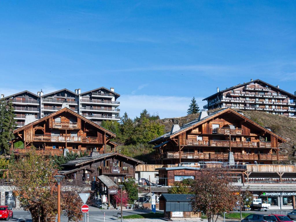 un grupo de edificios de madera con un gran edificio de apartamentos en Apartment Ferme D'Alice A2 by Interhome, en Nendaz