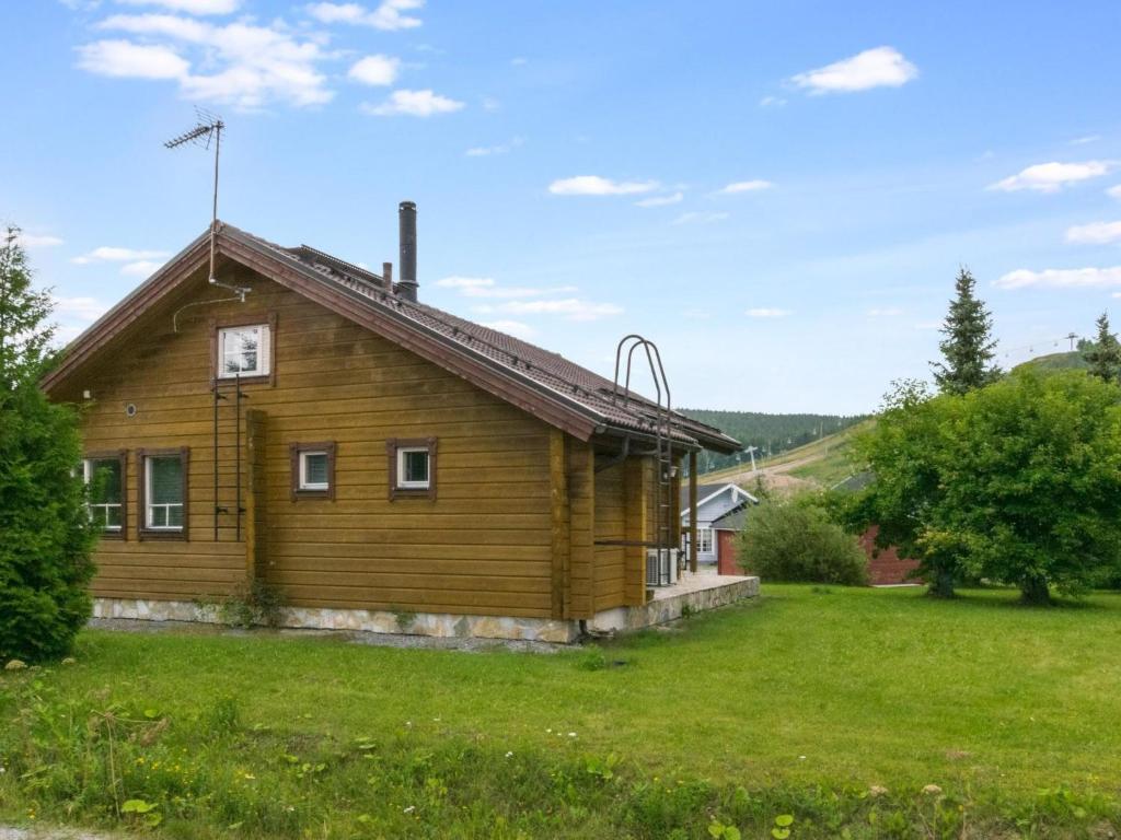 a wooden house in a field with a green yard at Holiday Home Himosaurinko by Interhome in Jämsä