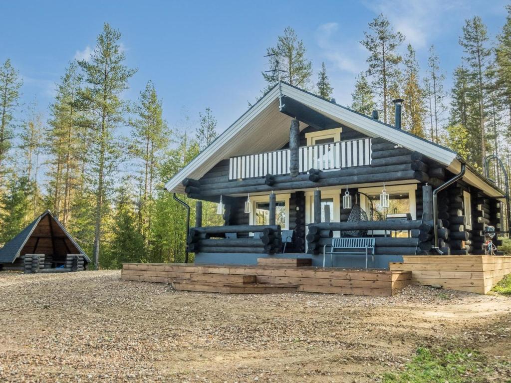a log home with a porch and a house at Holiday Home Vaaranpää by Interhome in Meltaus