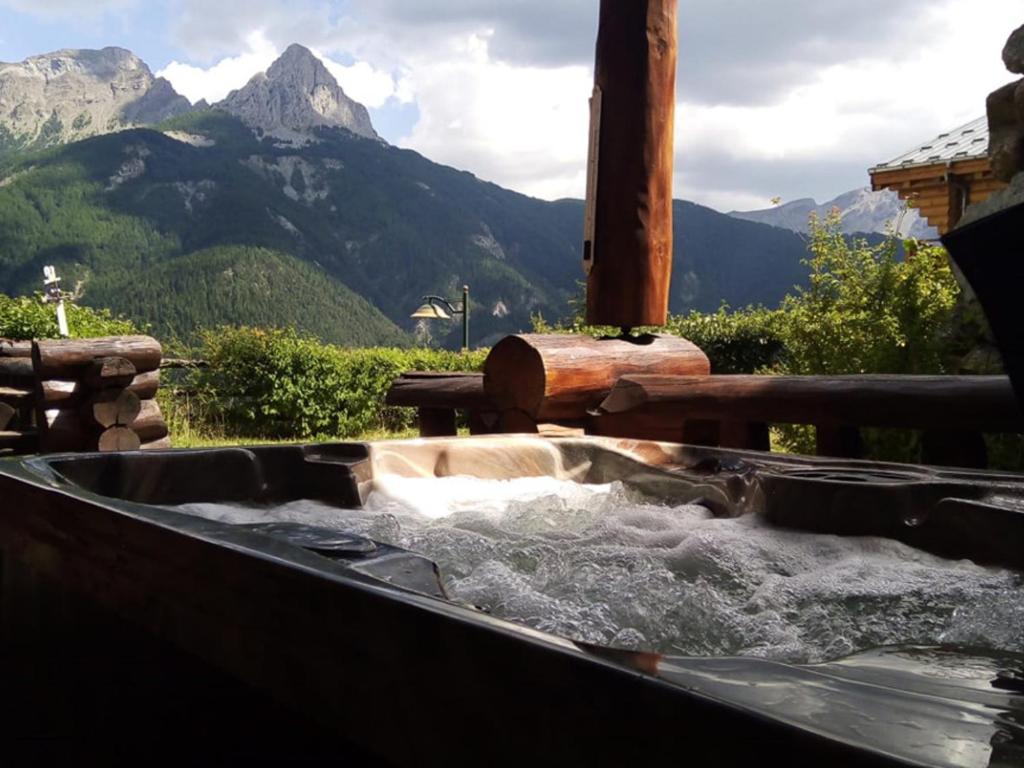 a tub filled with water with mountains in the background at Chalet Pra-Loup, 5 pièces, 8 personnes - FR-1-165A-126 in Uvernet