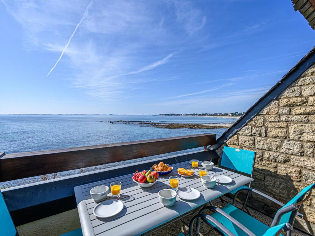 a table with food and drinks on a balcony overlooking the ocean at Apartment Plein Océan-3 by Interhome in Carnac