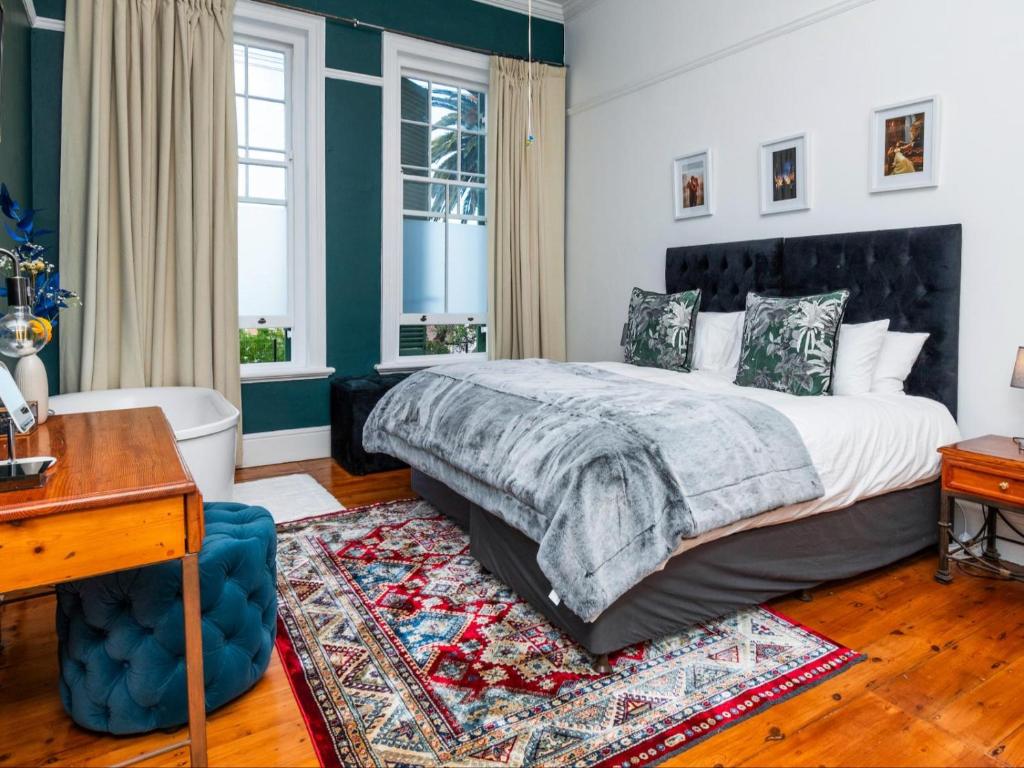 1 dormitorio con cama y escritorio en Belvedere House, en Ciudad del Cabo