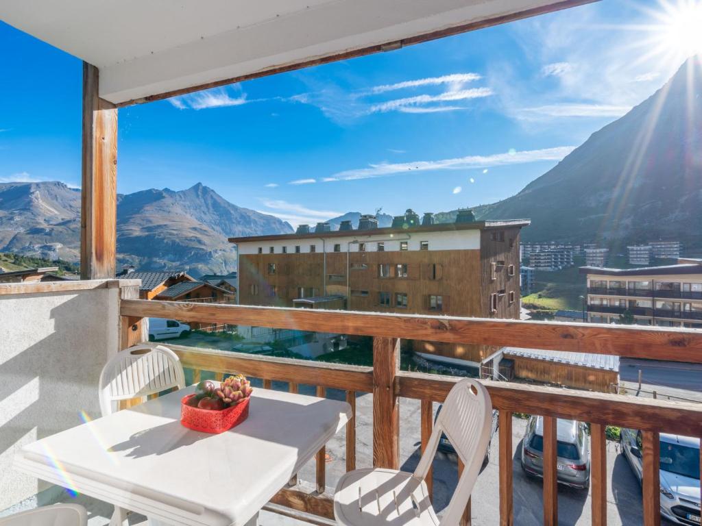 une table et des chaises sur un balcon avec vue sur les montagnes dans l'établissement Apartment Les Grandes Balmes I et II - Le Lac-11 by Interhome, à Tignes