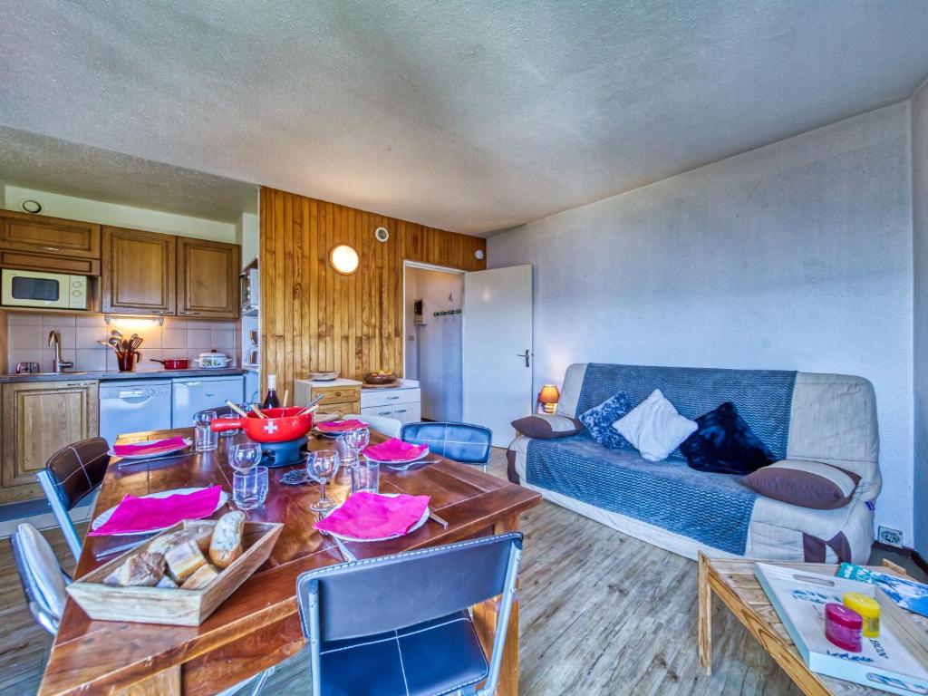 een woonkamer met een tafel en een bank bij Apartment Baikonour-8 by Interhome in Le Corbier
