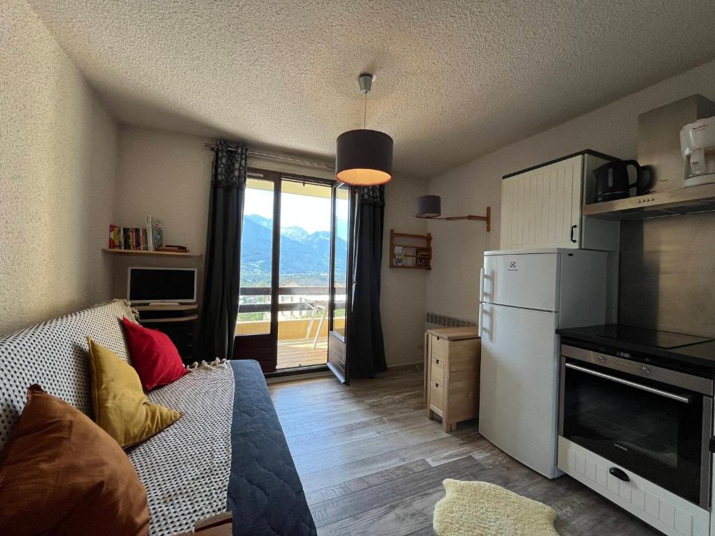 - un salon avec un canapé et un réfrigérateur dans l'établissement Appartement cosy à Barcelonnette, 4 pers, balcon, TV, cuisine équipée - FR-1-165A-156, à Barcelonnette
