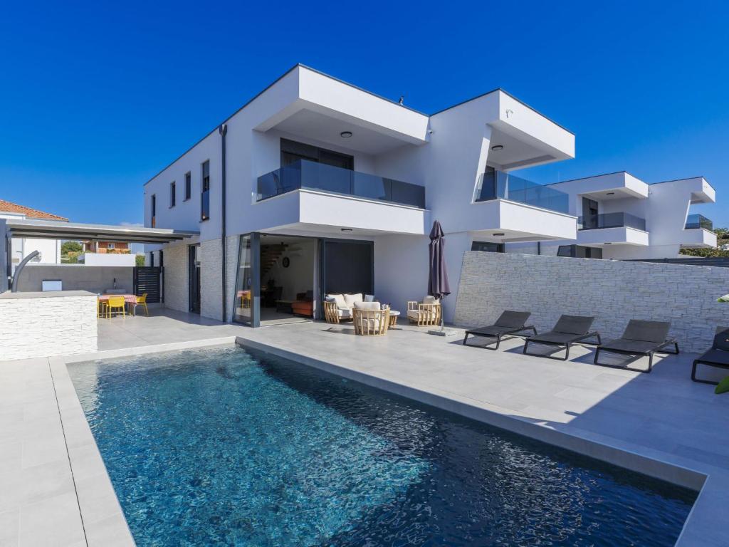 eine Villa mit Swimmingpool und ein Haus in der Unterkunft Holiday Home Villa MI by Interhome in Pula