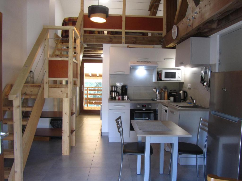 a kitchen with a table and a staircase in a room at GÎTE de DRAGOUX in Bas Bouvante