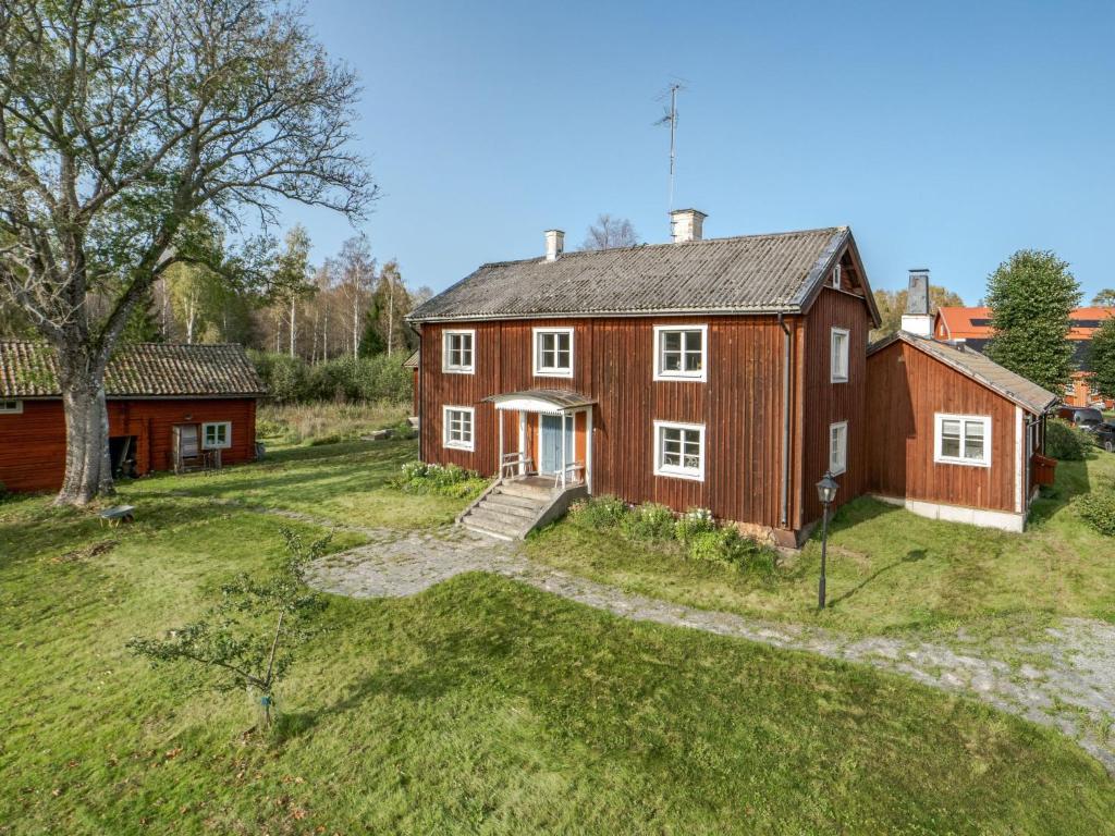 una gran casa roja en un campo de hierba en Holiday Home Karsbo gård - VML114 by Interhome, en Norberg