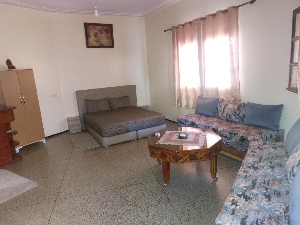 a living room with a couch and a bed at Studio Meknes Hamria in Meknès