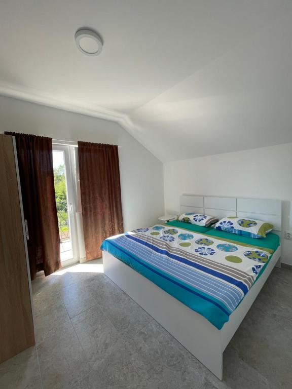 a bedroom with a bed with a blue comforter at Vikendica Villa Ramona Banja Luka in Banja Luka