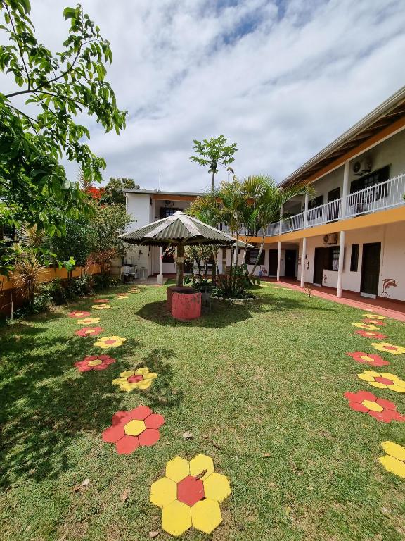 a yard with flowers on the grass in front of a building at Recanto Aconchego Itapoá in Itapoa