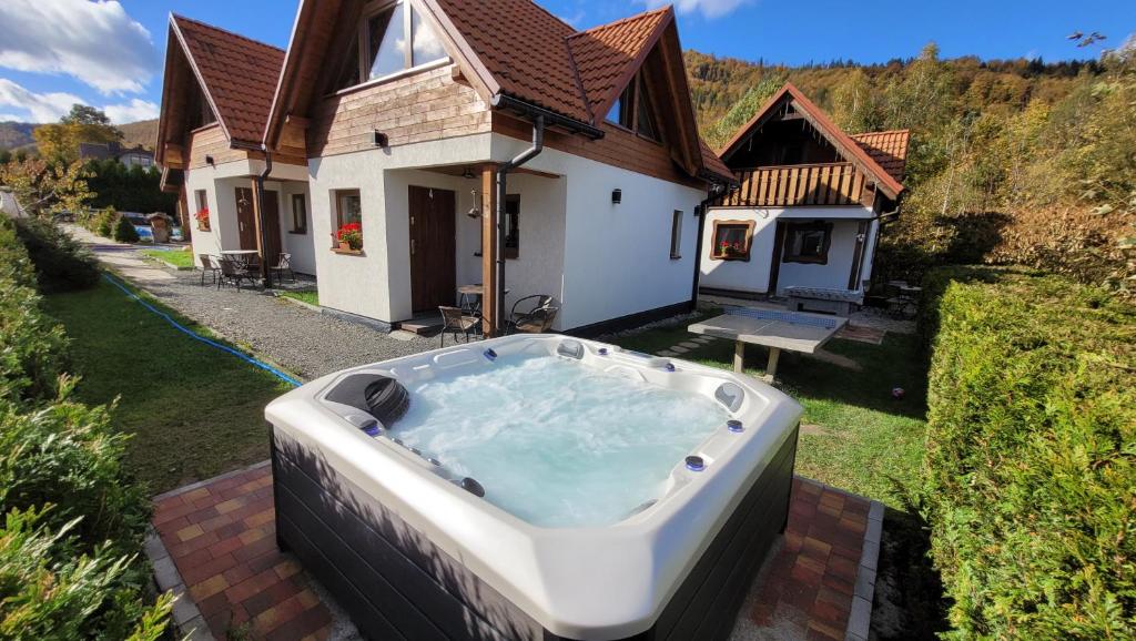 una bañera de hidromasaje en el patio de una casa en Mała Osada domki z jacuzzi przy gondoli en Szczyrk
