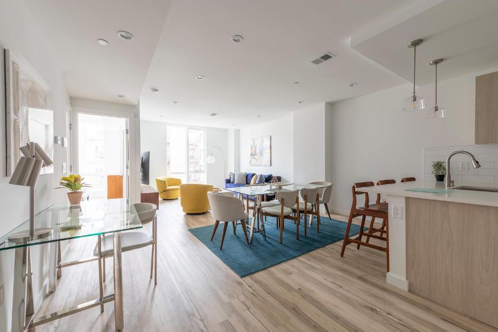 cocina y sala de estar con mesa y sillas en Sun-kissed 3BR Loft with Patio Minutes to NYC, en Hoboken