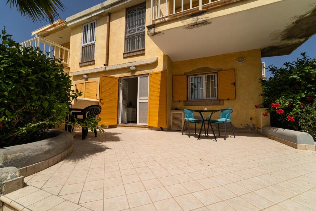 a patio with chairs and a table in front of a building at Lovely beach front apartment in Santa Maria in Santa Maria