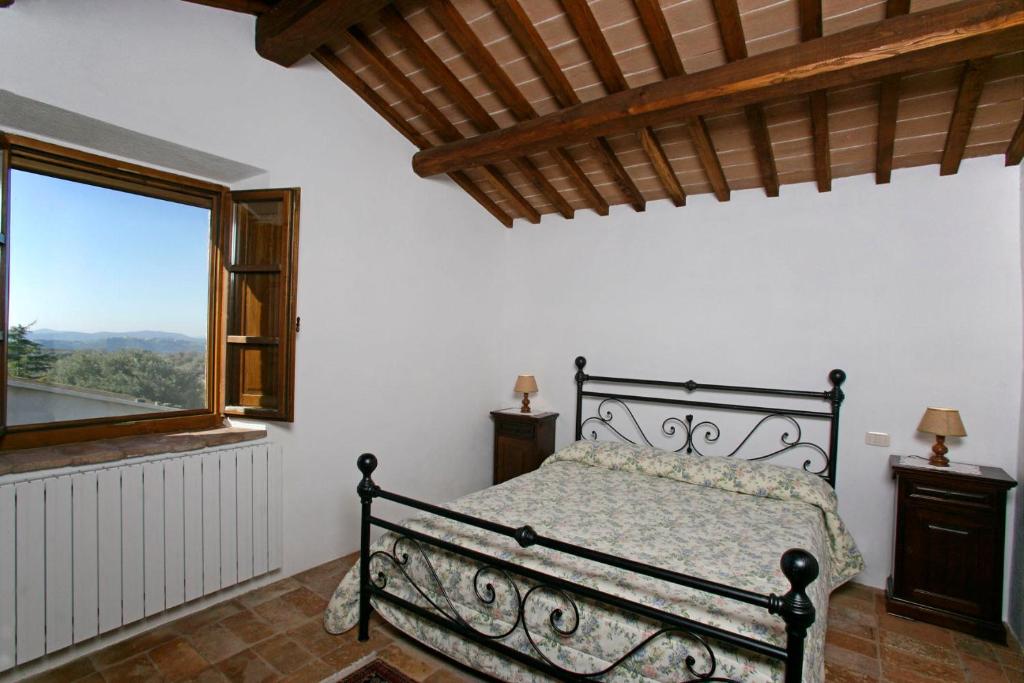 ein Schlafzimmer mit einem Bett und einem großen Fenster in der Unterkunft Appartamento Vermentino-Agriturismo Salustri in Cinigiano