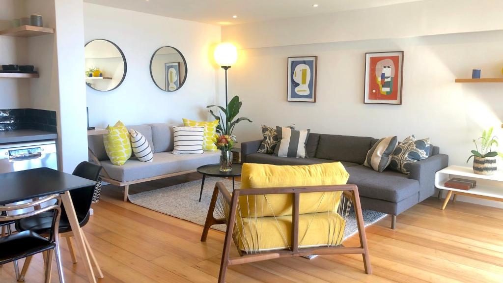 uma sala de estar com um sofá e uma mesa em Mountain and Harbour Views - Grand Vue Cottage em Cidade do Cabo