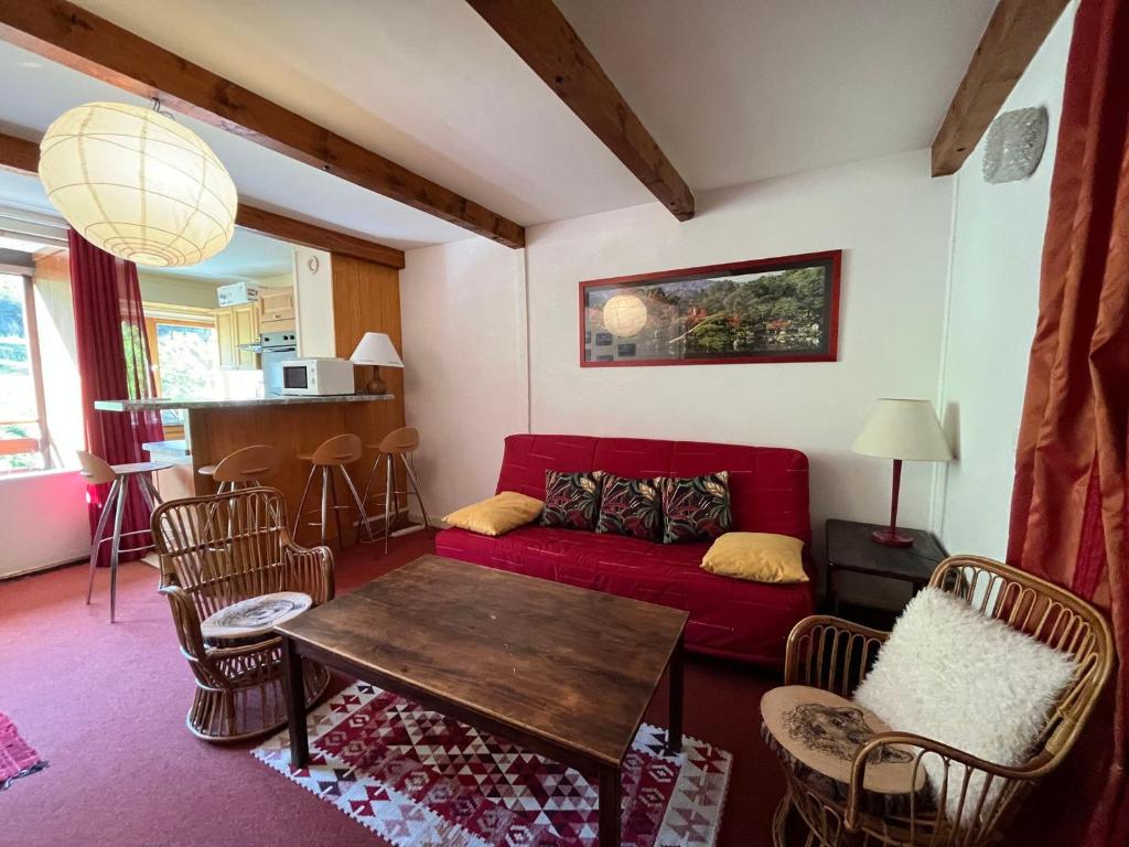 sala de estar con sofá rojo y sillas en Appartement Enchastrayes, 2 pièces, 6 personnes - FR-1-165A-26 en Enchastrayes
