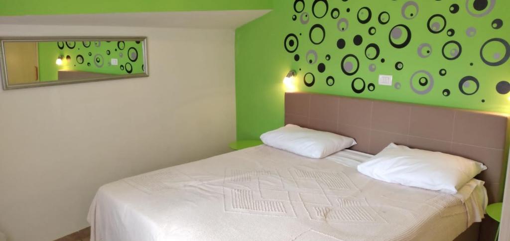 sypialnia z białym łóżkiem i zieloną ścianą w obiekcie Apartment in Medulin with sea view, balcony, air conditioning, W-LAN (112-5) w Medulinie
