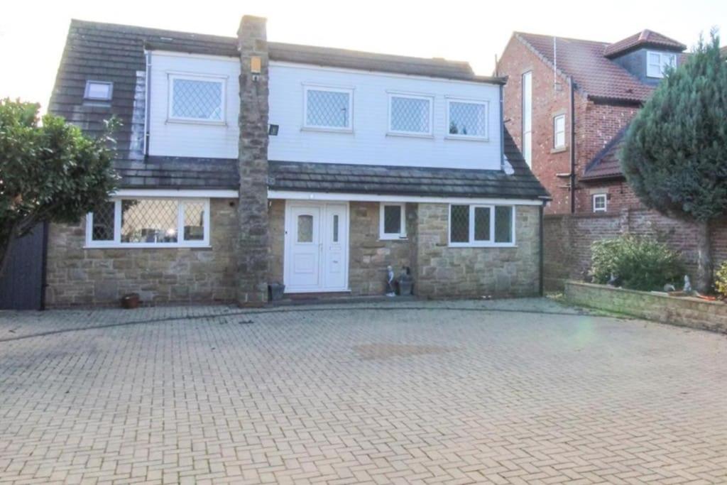 a brick house with a white door on a brick driveway at Spacious self-contained annexe in Horbury in Horbury