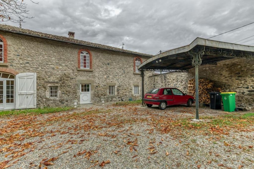 a red car parked in front of a stone building at Le Charme Antique¶ Belle maison¶ Centre Gières in Gières