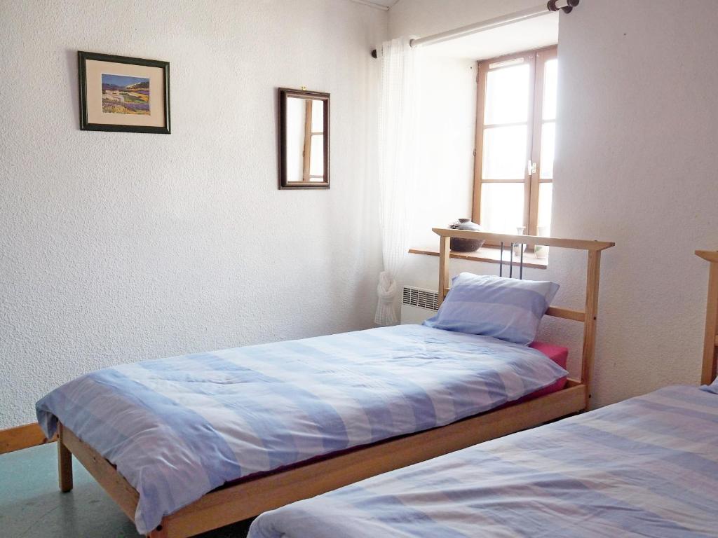 a bedroom with two beds and a window at Gencay La maison blanche in Gençay