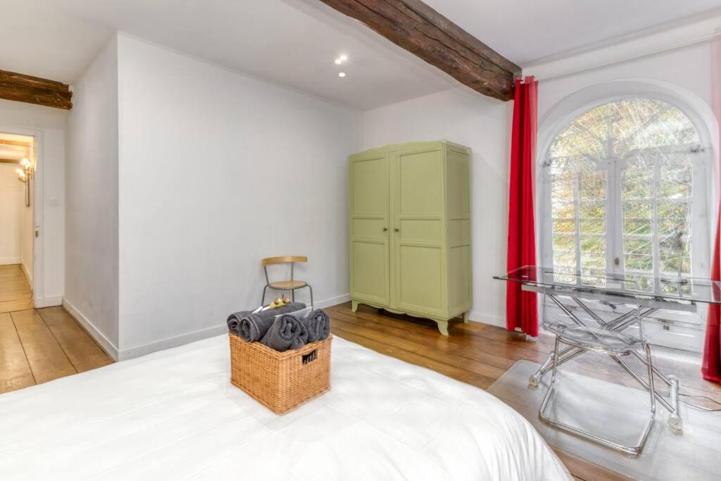 a bedroom with a bed and a dresser with red curtains at Le Charme Antique¶ Belle maison¶ Centre Gières in Gières