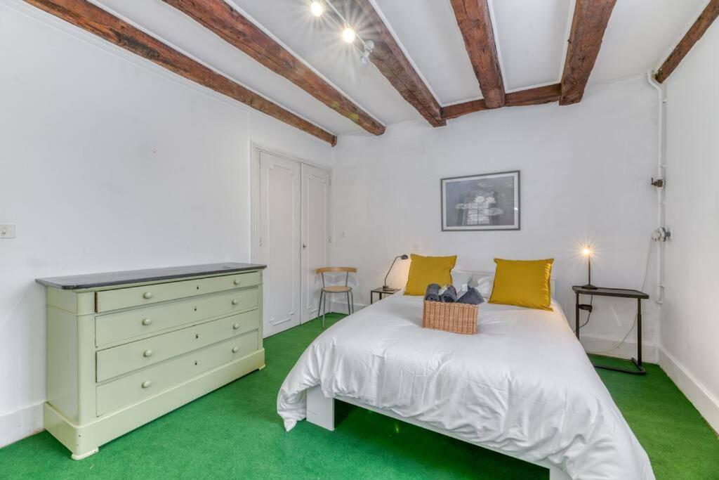 a bedroom with a bed and a dresser and green carpet at Le Charme Antique¶ Belle maison¶ Centre Gières in Gières