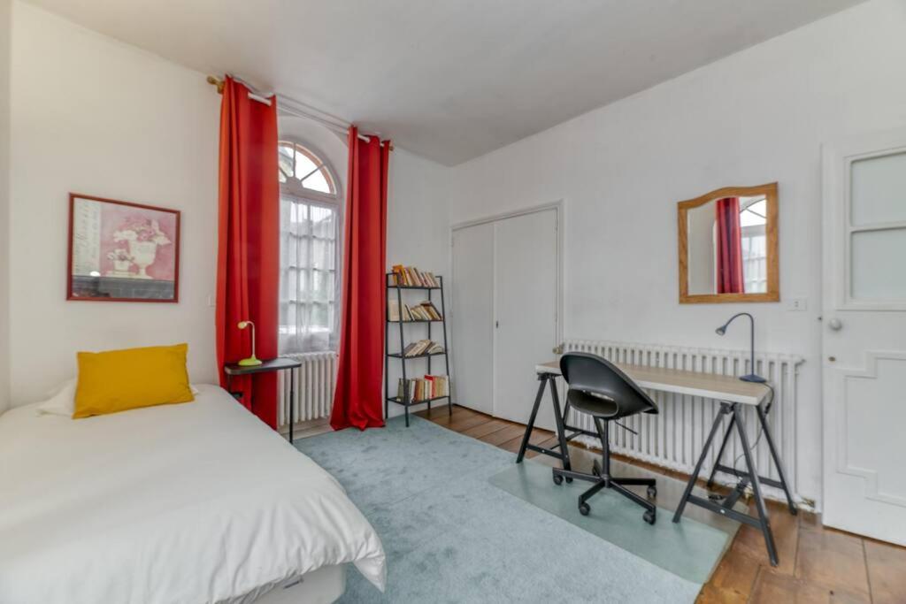 a bedroom with a bed and a desk and red curtains at Le Charme Antique¶ Belle maison¶ Centre Gières in Gières