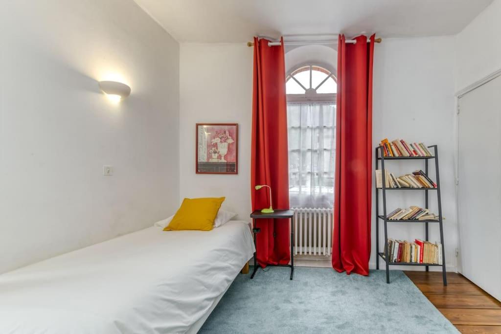 a room with a bed with red curtains and a window at Le Charme Antique¶ Belle maison¶ Centre Gières in Gières